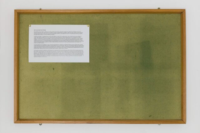 A close up of a green notice board with a piece of paper pinned to it.