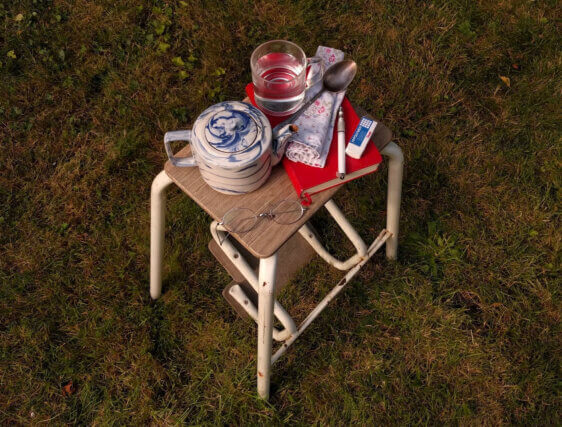 A top-down view of a workshop stool piled with artists' materials.