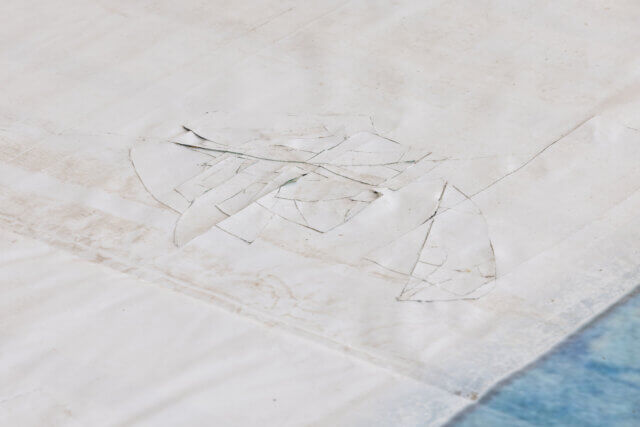 White Gallery space with large white installation on the floor with blue rectangular colourings