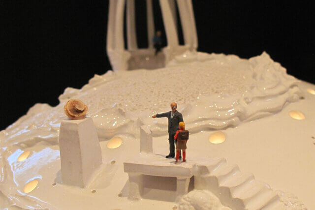 A ceramic sculpture depicting tiny figures in a park.