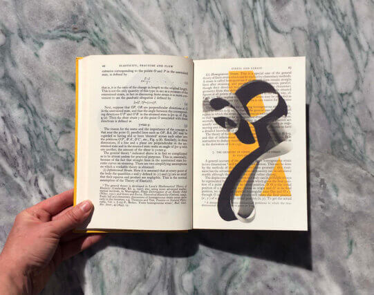 An image of an open book on a marble surface.