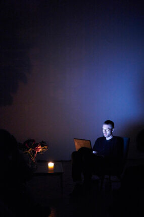 David Raymond Conroy, Progress Report: A Good Man, Reading with flowers and scented candle, David Raymond Conroy at Camden Arts Centre, 2014. Courtesy the artist and Camden Arts Centre. Photo: Pablo Antolí